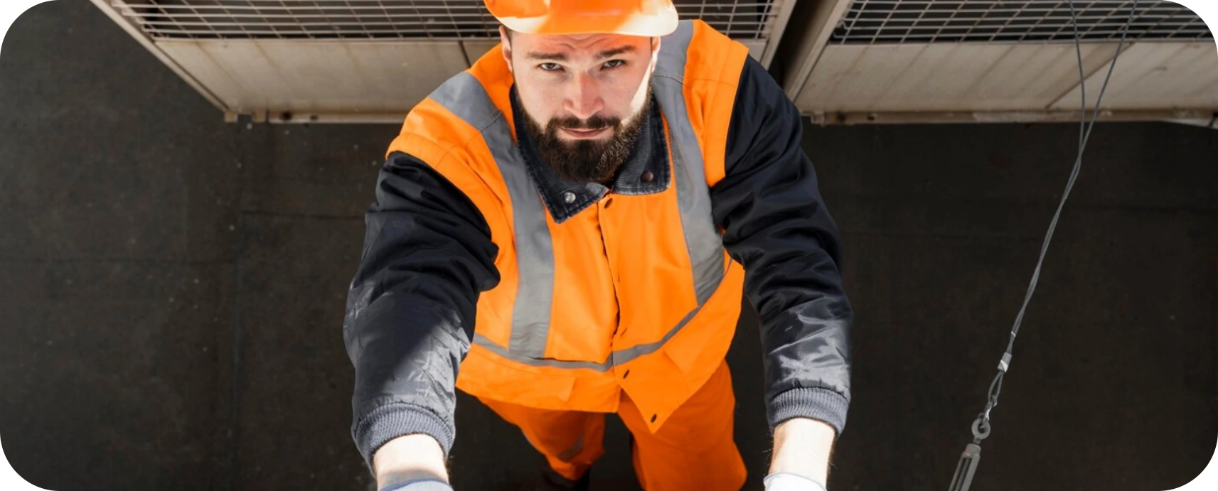 HVAC technician in orange safety vest performing maintenance