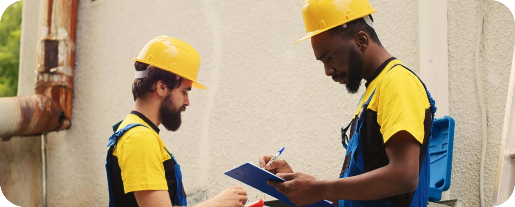 Two HVAC technicians reviewing maintenance checklist